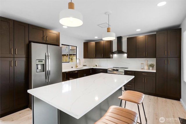 406 Center Pl, Everett, WA 98203 - kitchen featuring wall chimney exhaust hood, dishwashing machine, a sink, light wood-style flooring, and dark brown cabinets