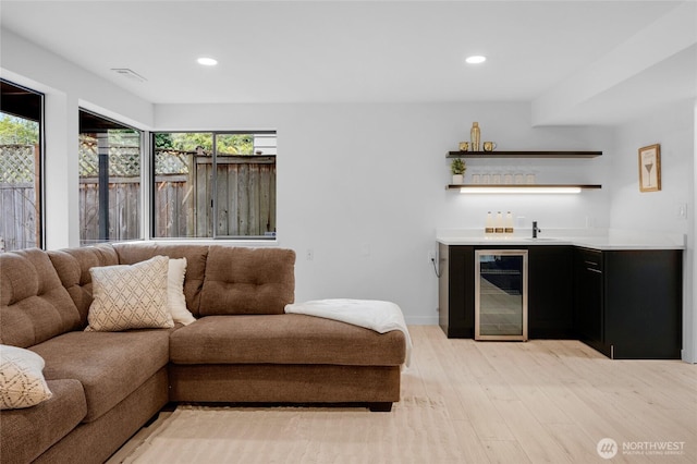 406 Center Pl, Everett, WA 98203 - living area featuring wine cooler, bar with sink, light wood-style floors, recessed lighting, and baseboards
