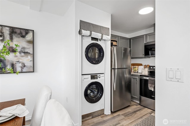 3717 California Ave SW Unit 304, Seattle, WA 98116 - washroom with stacked washer / dryer and light wood-style flooring