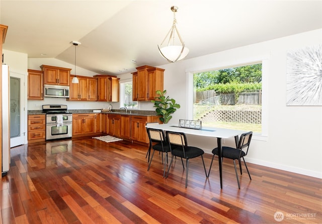 1416 Wilson Ave, Blaine, WA 98230 - kitchen featuring appliances with stainless steel finishes, brown cabinets, dark wood-style flooring, and lofted ceiling