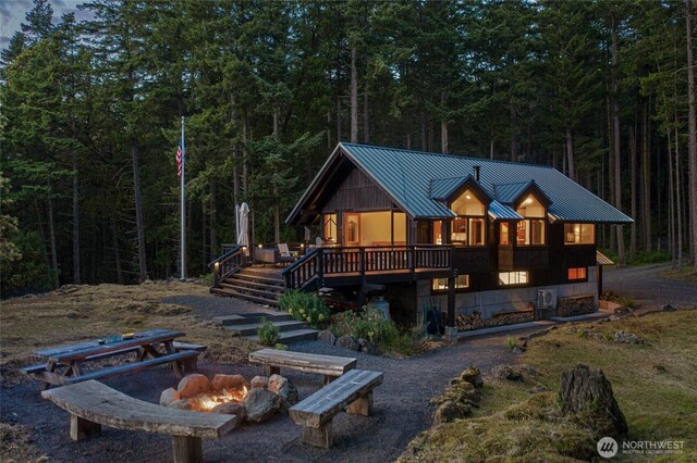 815 Carefree Way, Friday Harbor, WA 98250 - chalet / cabin with a fire pit, a standing seam roof, a metal roof, and a forest view