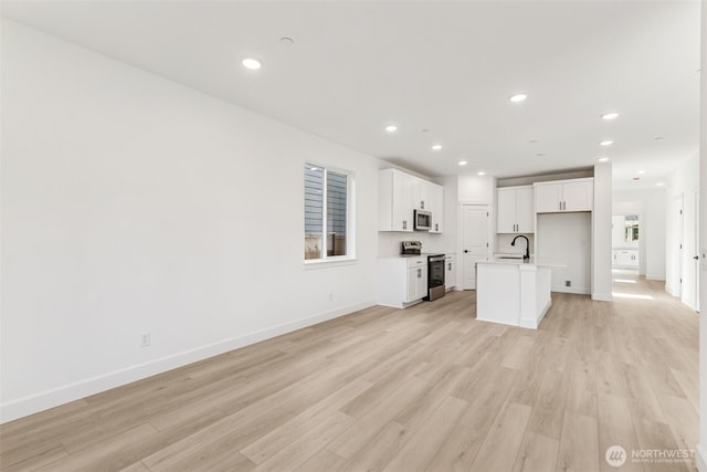 20620 97th Avenue St E Unit 16, Graham, WA 98338 - unfurnished living room with light wood finished floors, a sink, baseboards, and recessed lighting