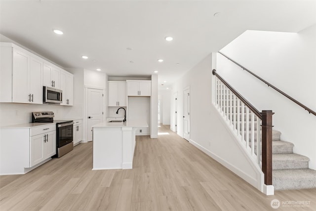 20620 97th Avenue St E Unit 16, Graham, WA 98338 - kitchen featuring stainless steel appliances, a sink, light wood-style flooring, recessed lighting, and white cabinets