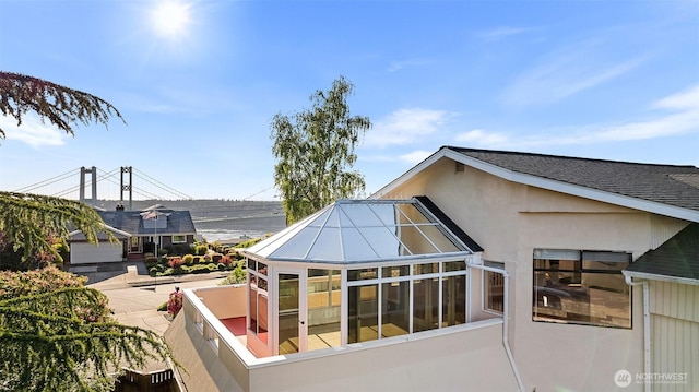 1550 N Narrows Dr, Tacoma, WA 98406 - view of property exterior featuring a sunroom, stucco siding, and roof with shingles