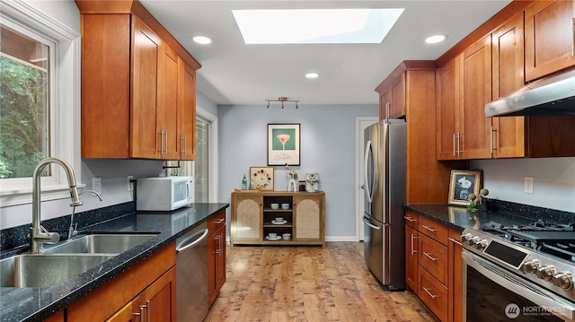 9824 NE 139th St, Kirkland, WA 98034 - kitchen featuring appliances with stainless steel finishes, a sink, a skylight, brown cabinetry, and recessed lighting