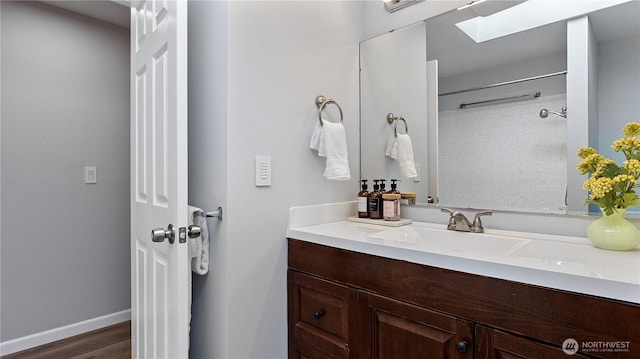 9824 NE 139th St, Kirkland, WA 98034 - full bathroom with vanity, wood finished floors, baseboards, and a skylight