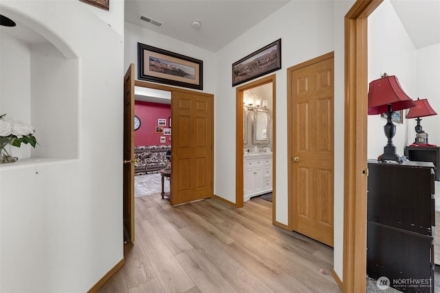 6940 35th St W, University Place, WA 98466 - hallway with arched walkways, light wood-style flooring, and baseboards