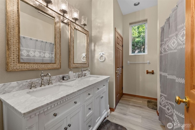 6940 35th St W, University Place, WA 98466 - bathroom featuring wood finished floors, double vanity, and baseboards