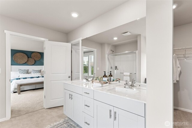 7318 281st Pl NW Unit 42, Stanwood, WA 98292 - ensuite bathroom featuring a shower stall, double vanity, a walk in closet, and recessed lighting