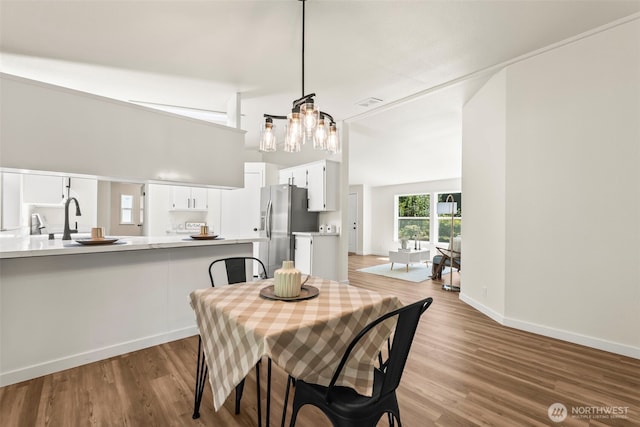 12323 Burchard Dr SW, Port Orchard, WA 98367 - dining space featuring a chandelier, wood finished floors, a towering ceiling, and baseboards