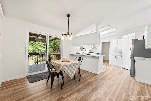 12323 Burchard Dr SW, Port Orchard, WA 98367 - dining room with vaulted ceiling, light wood-type flooring, a chandelier, and baseboards