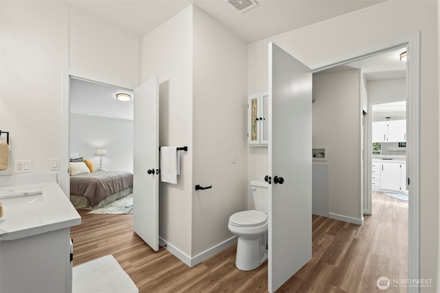 12323 Burchard Dr SW, Port Orchard, WA 98367 - bathroom featuring wood finished floors, connected bathroom, toilet, vanity, and baseboards