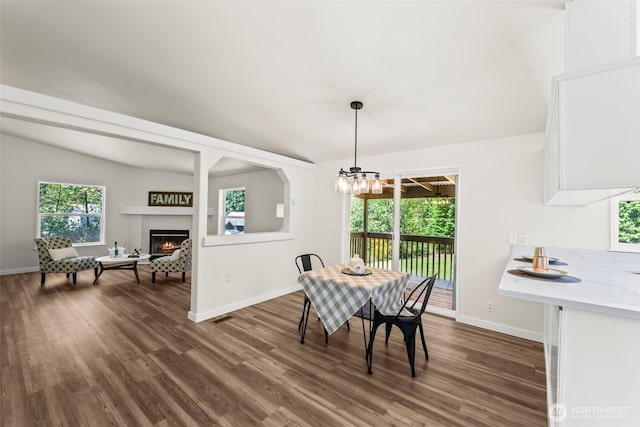12323 Burchard Dr SW, Port Orchard, WA 98367 - dining space featuring a chandelier, baseboards, dark wood-type flooring, a fireplace, and lofted ceiling