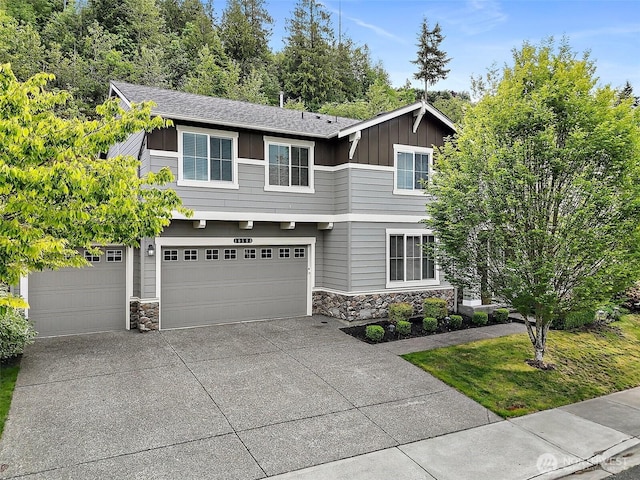 10508 174th Ave E, Bonney Lake, WA 98391 - view of front facade with stone siding, board and batten siding, driveway, and an attached garage