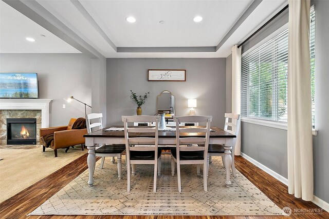 10508 174th Ave E, Bonney Lake, WA 98391 - dining room with wood finished floors, a premium fireplace, a tray ceiling, recessed lighting, and baseboards