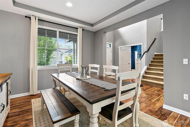 10508 174th Ave E, Bonney Lake, WA 98391 - dining space with baseboards, stairs, dark wood-style floors, recessed lighting, and a tray ceiling