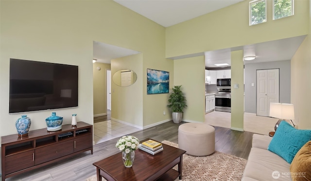 14600 SE 176th St Unit V1, Renton, WA 98058 - living area with light wood-style flooring, a high ceiling, and baseboards