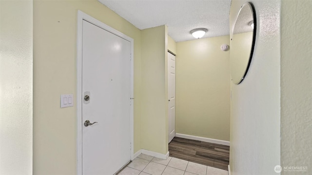 14600 SE 176th St Unit V1, Renton, WA 98058 - hallway featuring light tile patterned floors, baseboards, and a textured ceiling