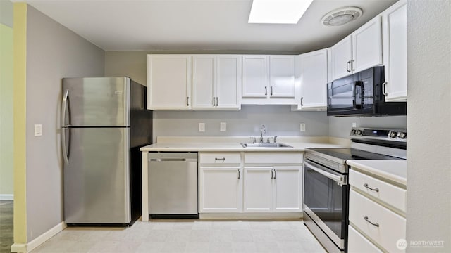 14600 SE 176th St Unit V1, Renton, WA 98058 - kitchen with stainless steel appliances, a sink, white cabinets, light countertops, and a skylight