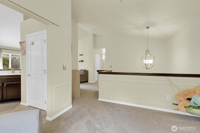 9505 S 214th Pl, Kent, WA 98031 - kitchen featuring light carpet, dark brown cabinetry, a chandelier, pendant lighting, and wainscoting