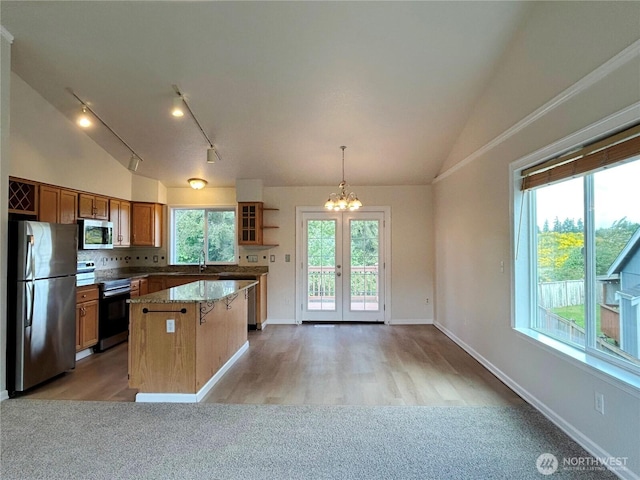 9002 Shadberry Dr SE, Olympia, WA 98513 - kitchen with stainless steel appliances, vaulted ceiling, a center island, rail lighting, and a chandelier