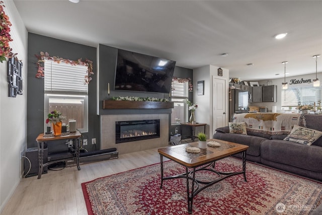15028 Iverson Loop SE, Yelm, WA 98597 - living room featuring light wood-type flooring, a glass covered fireplace, baseboards, and recessed lighting
