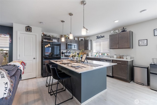 15028 Iverson Loop SE, Yelm, WA 98597 - kitchen with stainless steel appliances, dark brown cabinetry, light countertops, and recessed lighting