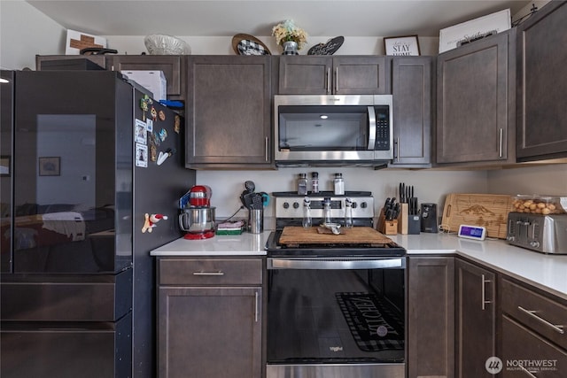 15028 Iverson Loop SE, Yelm, WA 98597 - kitchen featuring appliances with stainless steel finishes, dark brown cabinets, and light countertops