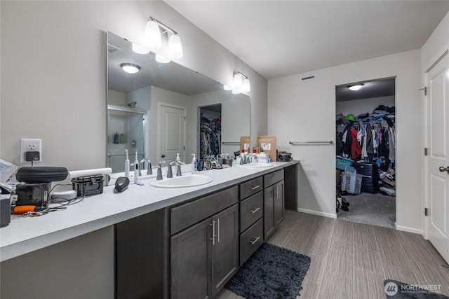 15028 Iverson Loop SE, Yelm, WA 98597 - bathroom featuring a spacious closet, a shower stall, and double vanity