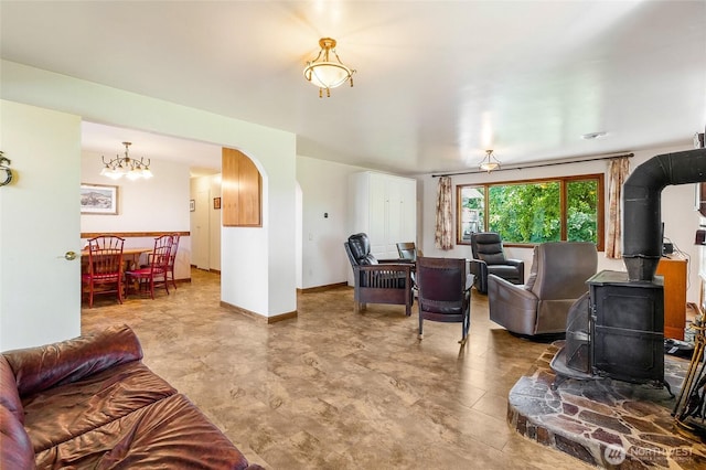 11801 Rd K NE, Moses Lake, WA 98837 - living room featuring a wood stove, arched walkways, a chandelier, and baseboards
