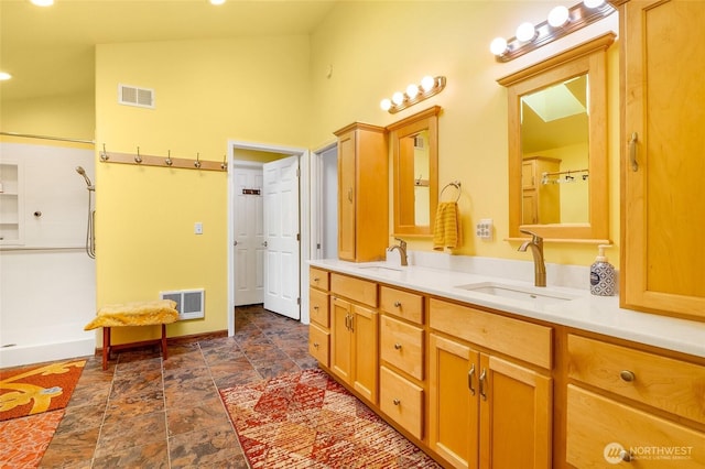 11801 Rd K NE, Moses Lake, WA 98837 - bathroom featuring double vanity, a shower, stone finish floors, a high ceiling, and baseboards