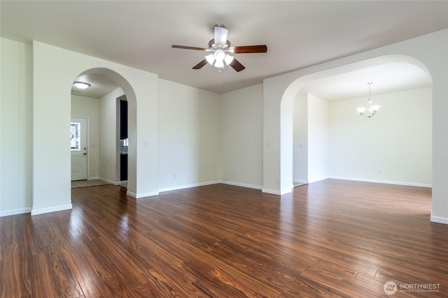 78 Cranbrook Ln, Walla Walla, WA 99362 - empty room featuring arched walkways, dark wood-type flooring, a ceiling fan, and a chandelier