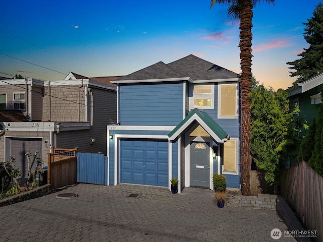 212 27th Ave E, Seattle, WA 98112 - traditional home featuring a garage, a shingled roof, and decorative driveway