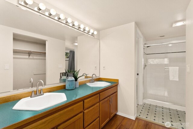 212 27th Ave E, Seattle, WA 98112 - bathroom with double vanity, a stall shower, and baseboards