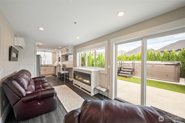 106 Shypoke Pl, Entiat, WA 98822 - living room featuring dark wood-style flooring, a wall mounted air conditioner, recessed lighting, and a glass covered fireplace
