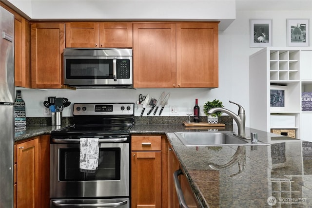 12303 Harbour Point Blvd Unit Ff306, Mukilteo, WA 98275 - kitchen with appliances with stainless steel finishes, a sink, brown cabinetry, and dark stone countertops
