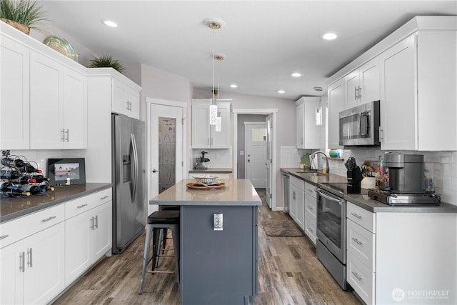 207 Moon River Vw SW, Mattawa, WA 99349 - kitchen with appliances with stainless steel finishes, a sink, decorative backsplash, white cabinetry, and a kitchen breakfast bar