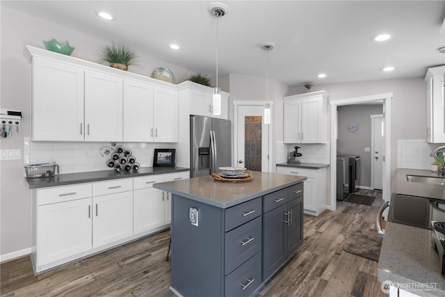 207 Moon River Vw SW, Mattawa, WA 99349 - kitchen featuring stainless steel fridge, washing machine and clothes dryer, a sink, decorative backsplash, and white cabinets