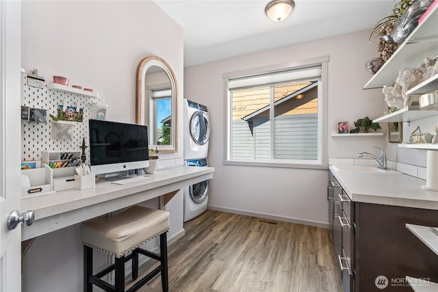 1080 Sunset Ln, Chelan, WA 98816 - home office with stacked washer / drying machine, a sink, light wood-style floors, and baseboards