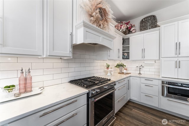 1080 Sunset Ln, Chelan, WA 98816 - kitchen with appliances with stainless steel finishes, backsplash, white cabinets, and dark wood-style flooring