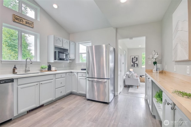 300 Cascade Ave, Granite Falls, WA 98252 - kitchen featuring stainless steel appliances, plenty of natural light, light countertops, light wood finished floors, and lofted ceiling