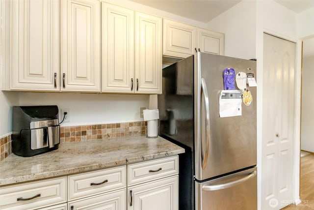 18909 SE 263rd St, Covington, WA 98042 - kitchen with freestanding refrigerator, light stone countertops, and cream cabinetry