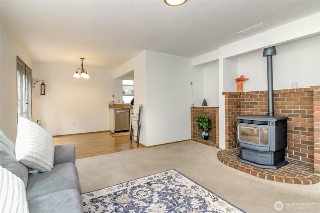 18909 SE 263rd St, Covington, WA 98042 - living room with carpet floors, a chandelier, baseboards, and a wood stove