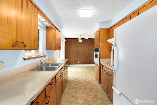 1642 Browns Point Blvd, Tacoma, WA 98422 - kitchen featuring white appliances, a sink, brown cabinetry, light countertops, and light flooring