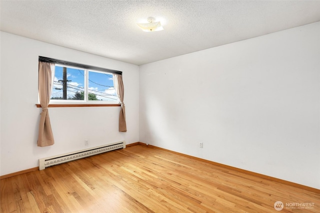 1642 Browns Point Blvd, Tacoma, WA 98422 - empty room featuring baseboard heating, light wood finished floors, baseboards, and a textured ceiling