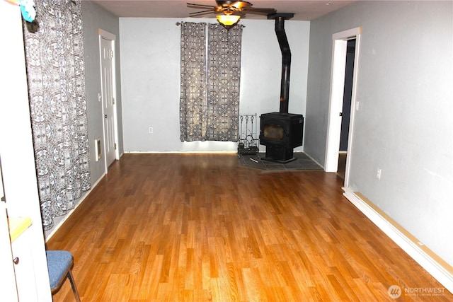 18343 Albany St SW, Rochester, WA 98579 - unfurnished living room with ceiling fan, wood finished floors, and a wood stove