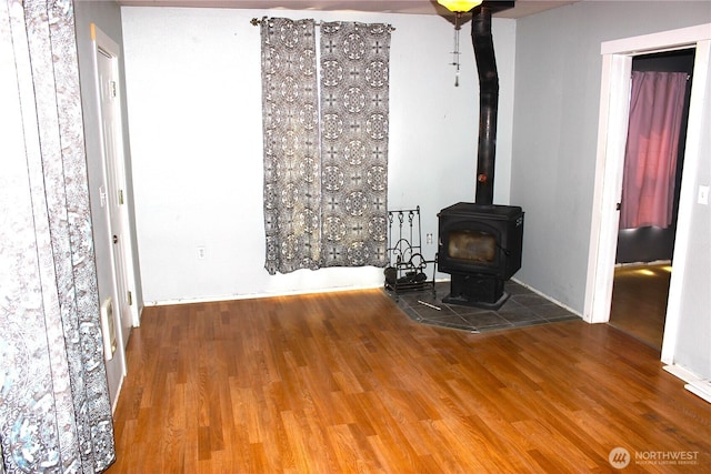 18343 Albany St SW, Rochester, WA 98579 - unfurnished living room featuring a wood stove and wood finished floors
