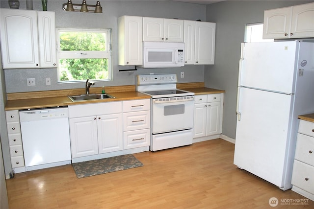 18343 Albany St SW, Rochester, WA 98579 - kitchen featuring white appliances, a sink, light wood-type flooring, and white cabinetry