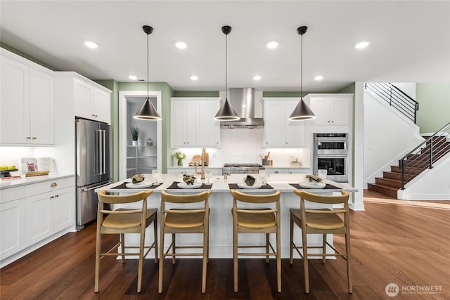 15306 204th Ave E Unit 23, Bonney Lake, WA 98391 - kitchen featuring wall chimney exhaust hood, stainless steel appliances, light countertops, dark wood-style flooring, and recessed lighting