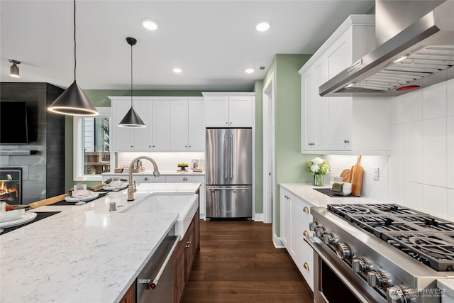 15306 204th Ave E Unit 23, Bonney Lake, WA 98391 - kitchen with appliances with stainless steel finishes, wall chimney range hood, a sink, white cabinets, and decorative backsplash